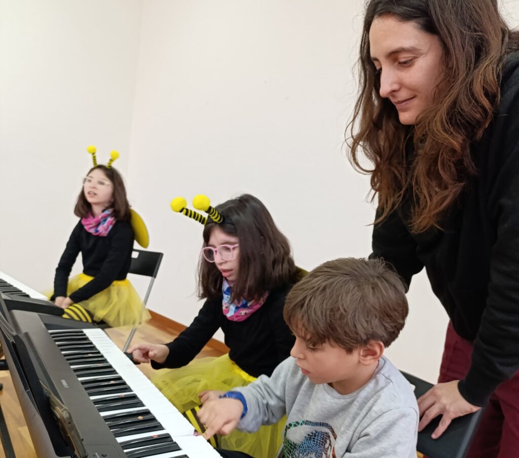 grupo de niños tocando el piano