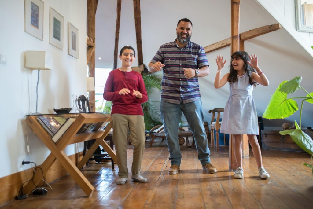 a man and two children dancing in a room