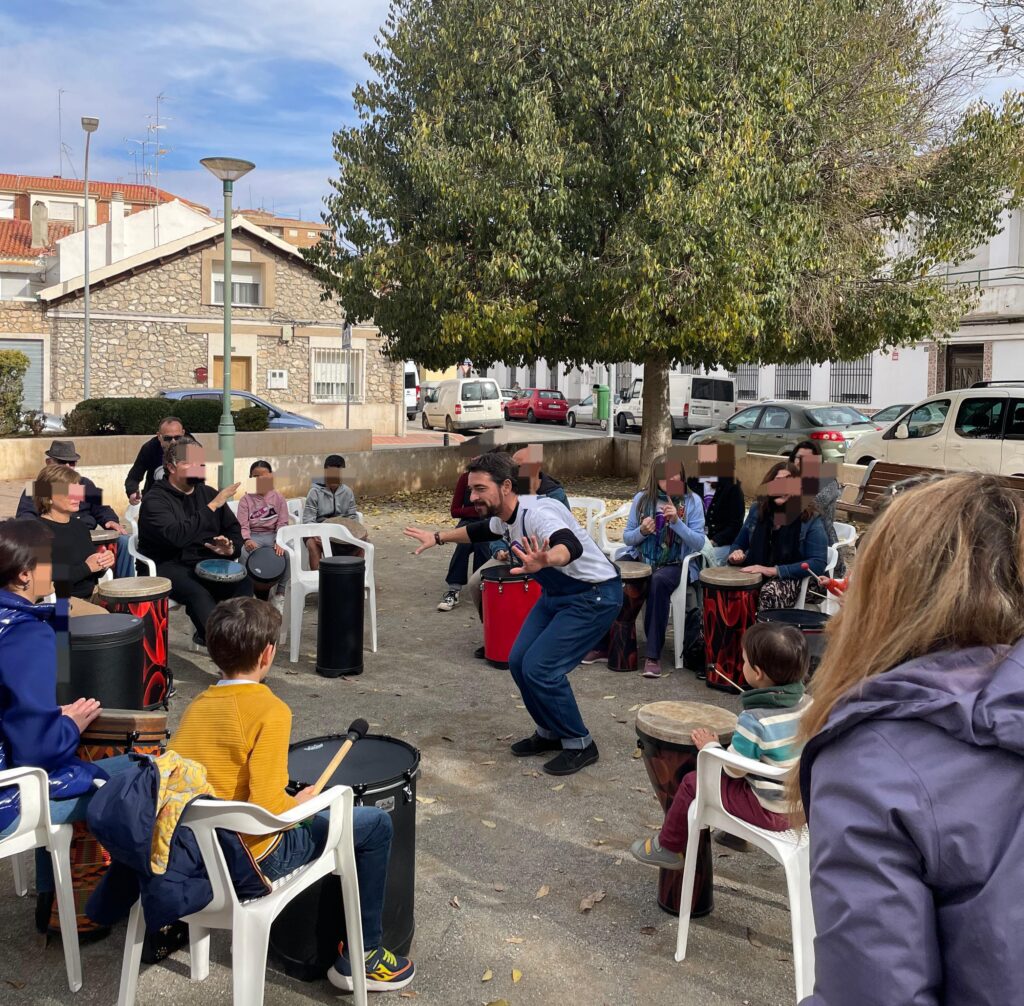 a group of people sitting around chairs and playing drums